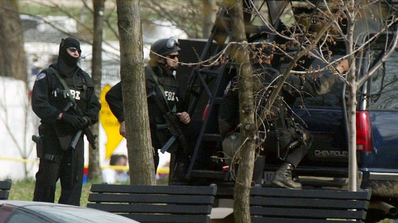 Agentes del FBI con engranajes de combate están junto a un vehículo. (Foto de Alex Wong / Getty Images)