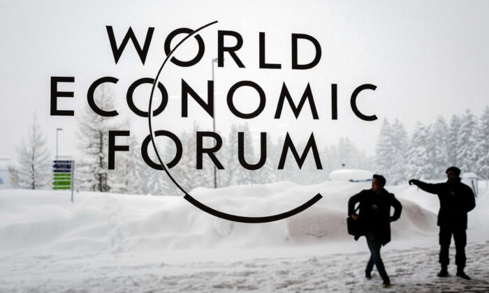 Un guardia de seguridad muestra el camino a un hombre en las afueras del Centro de Congresos de Davos bajo la nieve antes de la apertura de la reunión anual del Foro Económico Mundial (FEM) 2018, en Davos, Suiza, el 22 de enero de 2018. (Fabrice Coffrini/AFP a través de Getty Images)