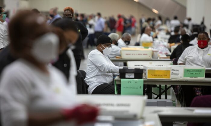 Trabajadores del Departamento de Elecciones de Detroit ayudan a procesar votos en ausencia en la Junta Central de Conteo en el Centro TCF en Detroit, Mich., el 4 de noviembre de 2020. (Elaine Cromie/Getty Images)