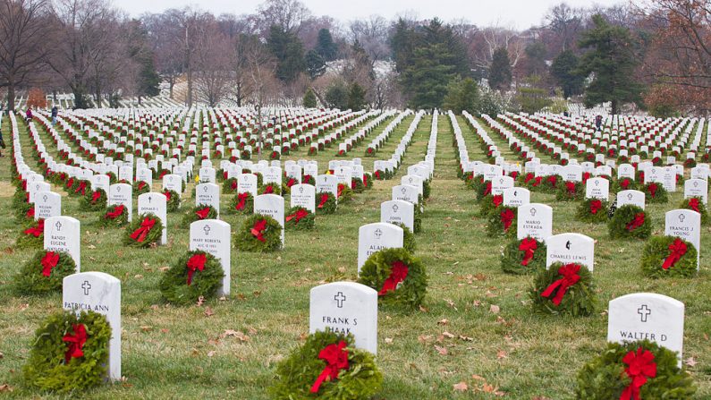 Los voluntarios de Wreaths Across America ayudan a colocar más de 100,000 guirnaldas conmemorativas en las lápidas del Cementerio Nacional de Arlington, Virginia, el 13 de diciembre de 2013. La misión de Wreaths Across America es recordar y honrar a los hombres y mujeres caídos de las fuerzas armadas coordinando Ceremonias de colocación de guirnaldas. (Foto del Ejército de los EE. UU. por el especialista James K. McCann)