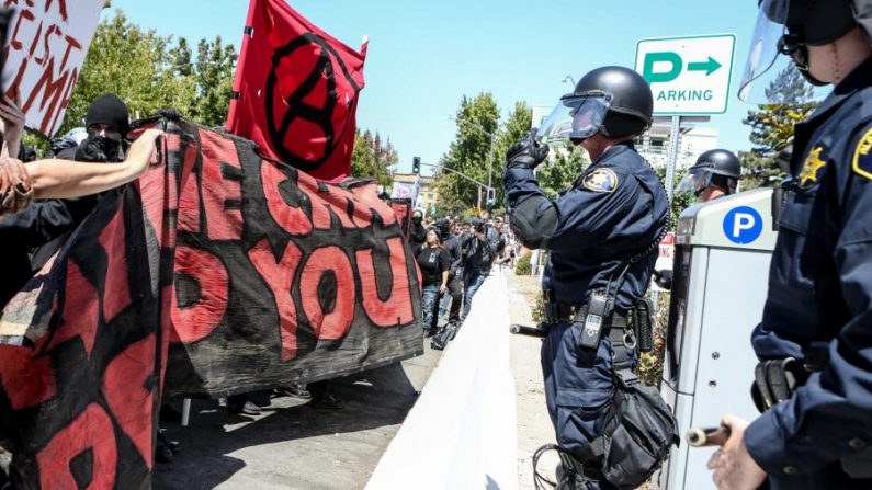 La policía antidisturbios permanece en guardia ante miembros de Antifa y contramanifestantes durante una manifestación "No al marxismo" en el parque Martin Luther King Jr. en Berkeley, California, el 27 de agosto de 2017. (Amy Osborne/AFP/Getty Images)