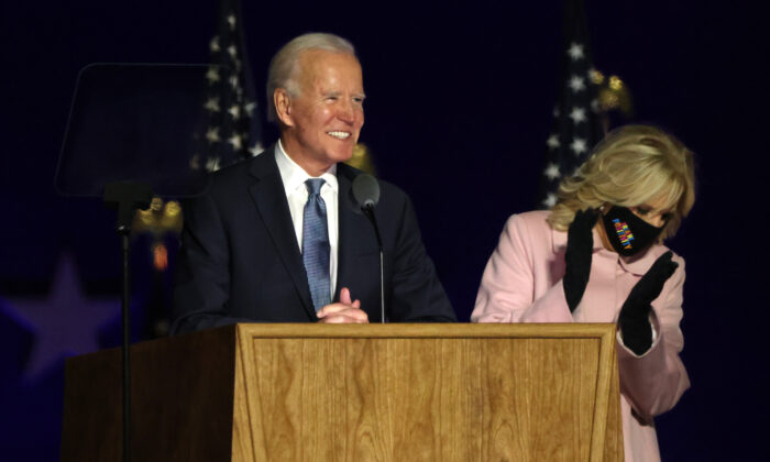 El candidato presidencial demócrata Joe Biden habla en un autocine la noche de las elecciones mientras su esposa Jill Biden aplaude a su lado, en el Chase Center en Wilmington, Delaware, a principios del 4 de noviembre de 2020. (Win McNamee/Getty Images)