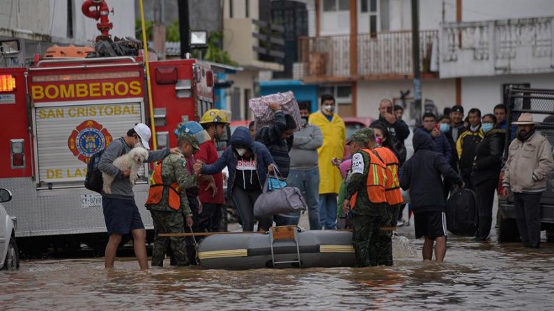 Policías estatales evacuan a familias de la zona inundada el 6 de noviembre de 2020, en el municipio de San Cristóbal de las Casas, en el estado de Chiapas (México). EFE/Carlos López