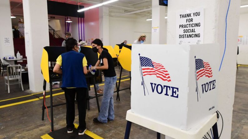 Un votante recibe asistencia de una trabajadora electoral en un centro de votación en Grand Central Market en Los Ángeles, California, el 3 de noviembre de 2020. (Frederic J. Brown/AFP a través de Getty Images)