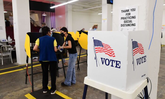 Un votante recibe asistencia de un trabajador electoral en un centro de votación en Grand Central Market en Los Ángeles, California, el 3 de noviembre de 2020. (Frederic J. Brown/AFP a través de Getty Images)