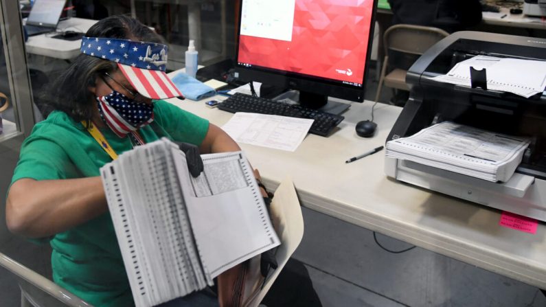 Un trabajador electoral del condado de Clark escanea las boletas de voto por correo en el Departamento de Elecciones del condado de Clark en North Las Vegas, Nev. el 7 de noviembre de 2020. (Ethan Miller/Getty Images)