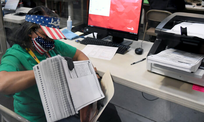 Una trabajadora electoral del condado de Clark escanea las boletas por correo en el Departamento de Elecciones del condado de Clark, en North Las Vegas, Nevada, el 7 de noviembre de 2020. (Ethan Miller/Getty Images)