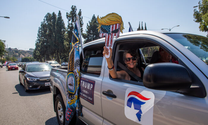Una mujer sostiene una careta pro-Trump durante una caravana en Long Beach, California, el 3 de octubre de 2020. (Apu Gomes AFP vía Getty Images)