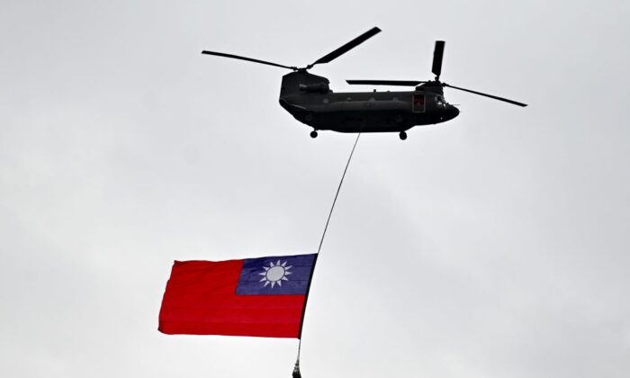 Un helicóptero militar vuela con la bandera nacional de Taiwán durante el día nacional frente al Despacho Presidencial en Taipei el 10 de octubre de 2020. (Sam Yeh/AFP vía Getty Images)