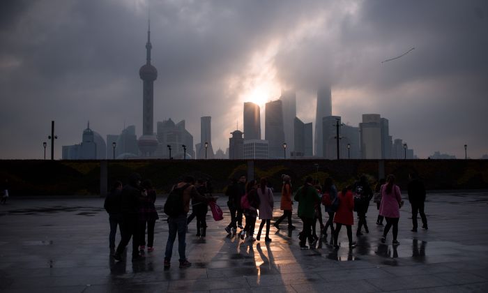 Un grupo de turistas se encuentra junto a Bund cerca del río Huangpu, al otro lado del Nuevo Distrito Financiero de Pudong, en Shanghai, China, el 14 de marzo de 2016. (Johannes Eisele/AFP/Getty Images)