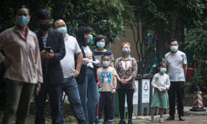 Residentes con mascarillas esperan en fila para la prueba de ácido nucleico en una comunidad residencial de Wuhan, la capital de la provincia china de Hubei, el 15 de mayo de 2020. (Getty Images)