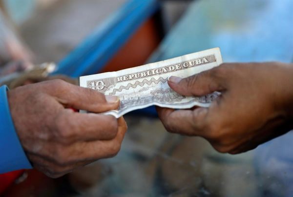 Un cliente paga con un billete de 10 pesos cubanos (CUP) a un vendedor de dulces en La Habana (Cuba). EFE/Yander Zamora/Archivo