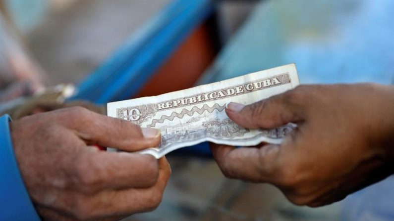 Un cliente paga con un billete de 10 pesos cubanos (CUP) a un vendedor de dulces en La Habana (Cuba). EFE/Yander Zamora/Archivo