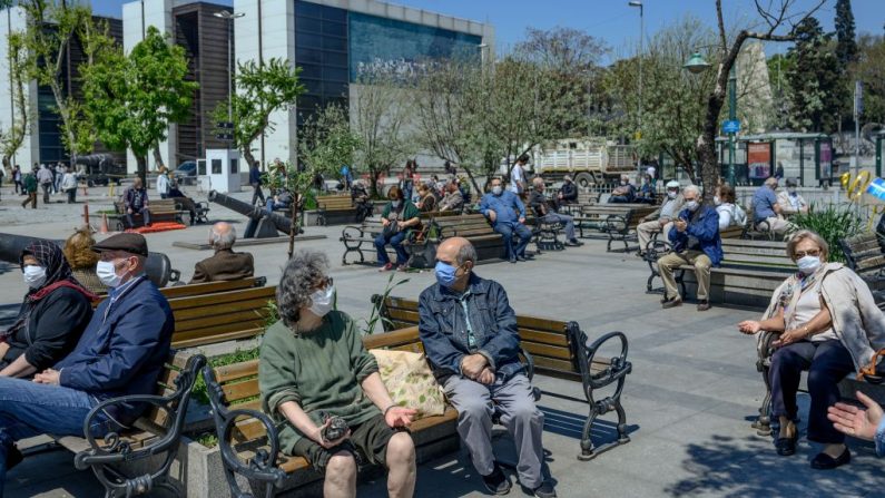 Las personas mayores con una mascarilla protectora se sientan y miran el Bósforo el 10 de mayo de 2020, en Besiktas, Estambul (Turquía), después de un mes y medio de restricciones de bloqueo destinadas a detener la propagación del covid-19. (Foto de BULENT KILIC / AFP a través de Getty Images)
