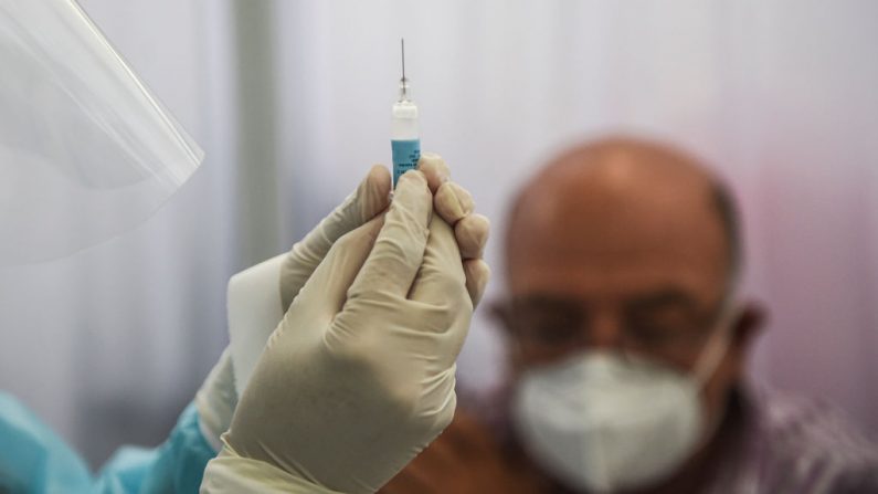 Una trabajadora sanitaria prepara una jeringa para inocular a un voluntario con una vacuna contra la COVID-19 producida por la China Sinopharm durante su ensayo en el Centro de Estudios Clínicos de la Universidad Cayetano Heredia en Lima (Perú), el 9 de diciembre de 2020. (Foto de ERNESTO BENAVIDES / AFP a través de Getty Images)