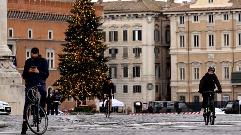 Los ciclistas andan en bicicleta en la casi vacía Via dei Fori el 24 de diciembre de 2020 en el centro de Roma (Italia). (Foto de VINCENZO PINTO / AFP a través de Getty Images)