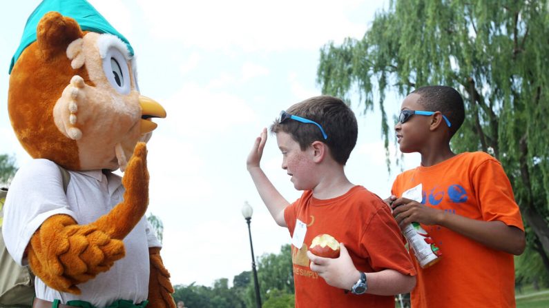 El niño choca los cinco con el ícono del Servicio Forestal de los Estados Unidos, el Búho Woodsy, en el Constitution Gardens del National Mall en Washington, D.C. 6 de junio de 2011. (Alex Wong/Getty Images)