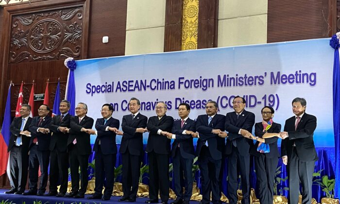 El secretario general de la ASEAN, Lim Jock Hoi, y los ministros de Relaciones Exteriores se dan la mano en el escenario en una cumbre entre China y la ASEAN (Asociación de Naciones del Sudeste Asiático) sobre el coronavirus COVID-19 en Vientiane, Laos, el 20 de febrero de 2020. (Dene-Hern Chen/AFP via Getty Images)