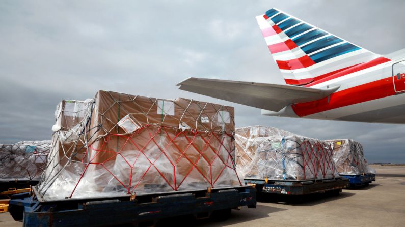 Los empleados de los servicios de flota de American Airlines se preparan para cargar paletas de carga en un 777-300 en el Aeropuerto Internacional de Dallas / Fort Worth (DFW), el 20 de marzo de 2020. (Foto de Tom Pennington / Getty Images)