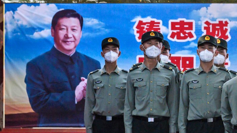 Soldados del Batallón de Guardia del Ejército Popular de Liberación usan mascarillas de protección mientras están de pie en atención a la foto del líder chino Xi Jinping en sus cuarteles en las afueras de la Ciudad Prohibida, cerca de la Plaza Tiananmen, el 20 de mayo de 2020 en Beijing, China. ( Kevin Frayer/Getty Images)