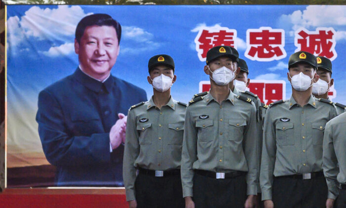 Soldados del Batallón de la Guardia de Honor del Ejército Popular de Liberación llevan máscaras protectoras mientras están de pie frente a una foto del líder del Partido Comunista Chino, Xi Jinping, en su cuartel en las afueras de la Ciudad Prohibida, cerca de la Plaza Tiananmen, en Beijing, el 20 de mayo de 2020. (Kevin Frayer/Getty Images)