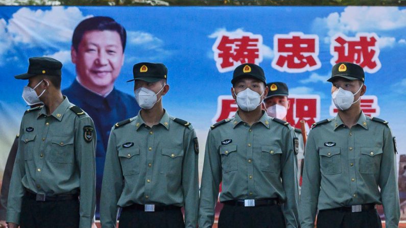 Soldados del Batallón de Guardia del Ejército Popular de Liberación usan máscaras protectoras mientras están de pie ante la foto de Xi Jinping en sus cuarteles en las afueras de la Ciudad Prohibida, cerca de la Plaza Tiananmen, el 20 de mayo de 2020 en Beijing, China. (Kevin Frayer/Getty Images)