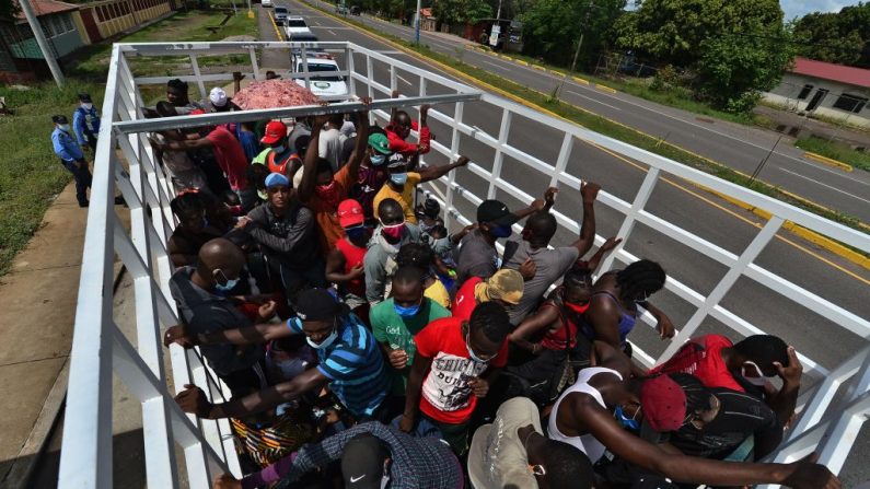 Casi un centenar de migrantes del Congo, Ghana, Costa de Marfil, Haití y Cuba que se dirigían en una caravana de Choluteca, Honduras, a México, el 3 de junio de 2020.  (ORLANDO SIERRA/AFP vía Getty Images)