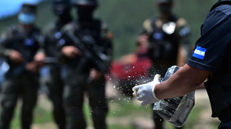 Miembros de la Dirección Técnica de Investigación Criminal de Honduras (ATIC) se preparan para quemar unos 250 kilos de cocaína, incautados el pasado mes de mayo, el 24 de julio de 2020 en Tegucigalpa. (Foto de ORLANDO SIERRA / AFP a través de Getty Images)