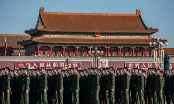 Soldados chinos del Ejército Popular de Liberación usan máscaras, mientras se alinean, antes de una ceremonia en la Plaza de Tiananmen, en Beijing, el 23 de octubre de 2020. (Kevin Frayer/Getty Images)