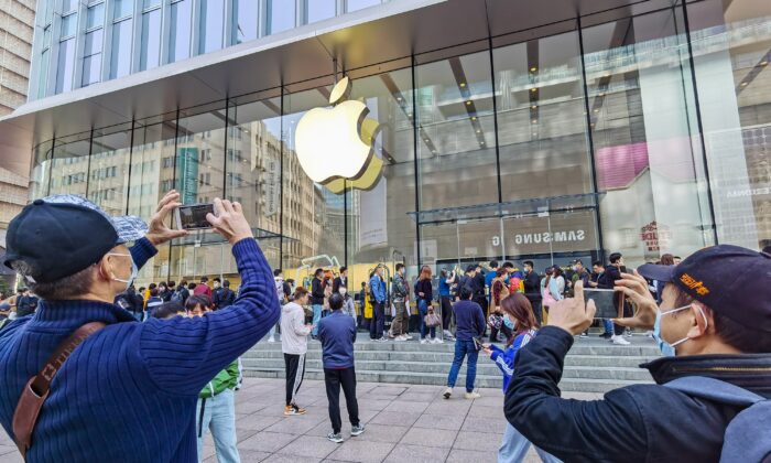 Clientes hacen cola para obtener teléfonos móviles iPhone 12 reservados, en una tienda Apple en Shanghai, el 23 de octubre de 2020. (STR/AFP a través de Getty Images)