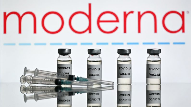Una ilustración muestra frascos con adhesivos de vacuna Covid-19 y jeringas con el logotipo de la empresa de biotecnología estadounidense Moderna el 17 de noviembre de 2020. (Foto de JUSTIN TALLIS/AFP a través de Getty Images)