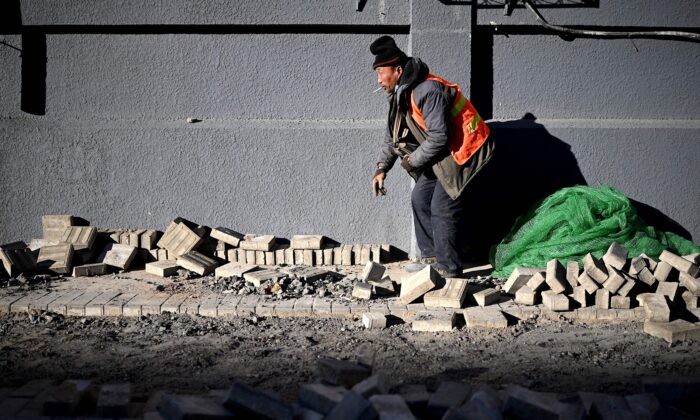 Un trabajador coloca ladrillos a lo largo de una calle en Beijing, China, el 4 de diciembre de 2020. (NOEL CELIS/AFP a través de Getty Images)