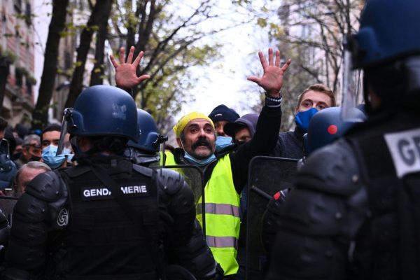 Un manifestante levanta la mano frente a los gendarmes móviles de Riot durante una manifestación por los 'derechos sociales' y contra el proyecto de ley de 'seguridad global', cuyo artículo 24 penalizaría la publicación de imágenes de policías en servicio con la intención de dañar a sus 'integridad física o psicológica', en París (Francia), el 5 de diciembre de 2020. (Foto de ANNE-CHRISTINE POUJOULAT / AFP a través de Getty Images)