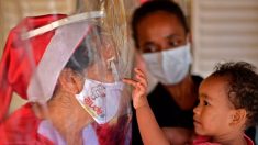 Mamá Claus brasileña usa cortina plástica para abrazar y llevar regalos a niños en plena pandemia