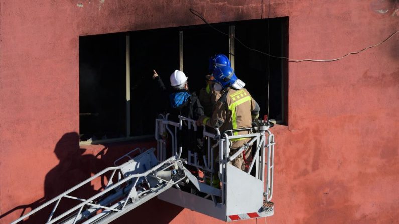 Los bomberos inspeccionan un almacén quemado donde vivían hasta 200 inmigrantes en condiciones miserables, el 10 de diciembre de 2020 en Badalona, cerca de Barcelona, un día después de que un incendio estallara matando al menos a dos personas e hiriendo a 17. (Foto de LLUIS GENE / AFP a través de Getty Images)