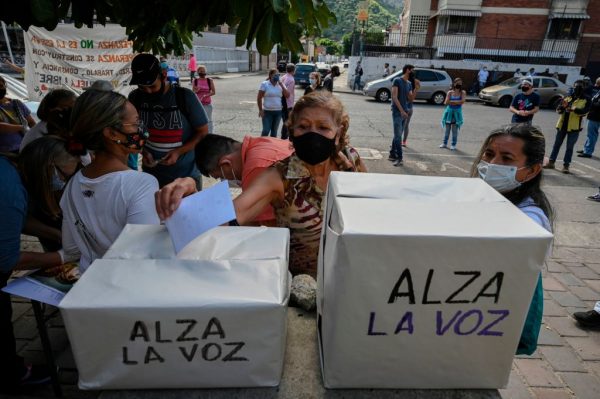 Una mujer venezolana emite su voto durante una "consulta popular" convocada por el presidente encargado venezolano Juan Guaidó en el barrio de San Juan, Caracas (Venezuela), el 12 de diciembre de 2020. (Foto de YURI CORTEZ / AFP a través de Getty Images)