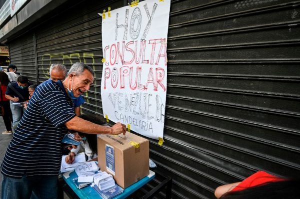 Un venezolano emite su voto durante una "consulta popular" convocada por el presidente encargado venezolano Juan Guaidó en el barrio La Candelaria, Caracas (Venezuela), el 12 de diciembre de 2020. (Foto de YURI CORTEZ / AFP a través de Getty Images)