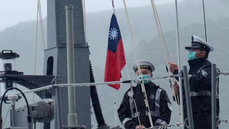 Dos soldados de la marina izan la bandera nacional de Taiwán durante una ceremonia oficial en un astillero de Su'ao, un municipio del condado de Yilan, en el este de Taiwán, el 15 de diciembre de 2020. (Sam Yeh/AFP vía Getty Images)
