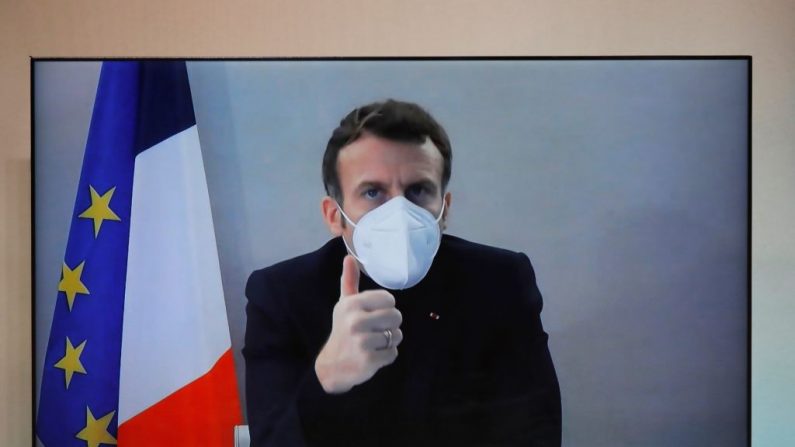 El presidente francés Emmanuel Macron, que dio positivo por la enfermedad del COVID-19, se ve en una pantalla mientras asiste por videoconferencia a una mesa redonda para la Conferencia Nacional Humanitaria (NHC) en el Ministerio de Relaciones Exteriores en París (Francia) el 17 de diciembre de 2020. (Foto de CHARLES PLATIAU / POOL / AFP a través de Getty Images)