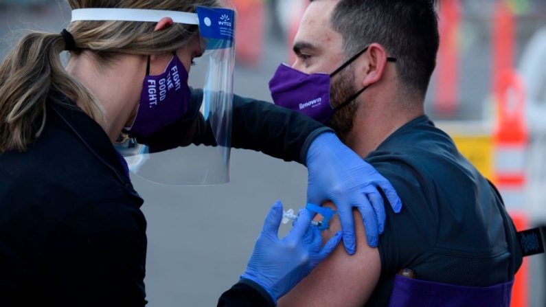 Una enfermera registrada (i) administra la primera dosis de la vacuna Pfizer-BioNTech covid-19 al trabajador de atención médica de primera línea Luis Martínez bajo una autorización de uso de emergencia en un sitio de vacunación de Renown Health en Reno, Nevada (EE.UU.), el 17 de diciembre de 2020. (Foto de PATRICK T.FALLON / AFP a través de Getty Images)