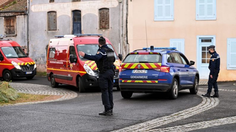 Un gendarme francés hace un gesto mientras los camiones de bomberos pasan por Saint-Just, en el centro de Francia, el 23 de diciembre de 2020, después de que tres gendarmes murieron y un cuarto resultó herido por un pistolero al que se enfrentaron en respuesta a una llamada de violencia doméstica. (Foto de OLIVIER CHASSIGNOLE / AFP a través de Getty Images)