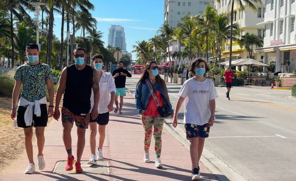 Personas con mascarillas caminan en Miami Beach, Florida (EE.UU.) el 22 de diciembre de 2020 en medio de la pandemia de covid-19. (Foto de DANIEL SLIM / AFP a través de Getty Images)