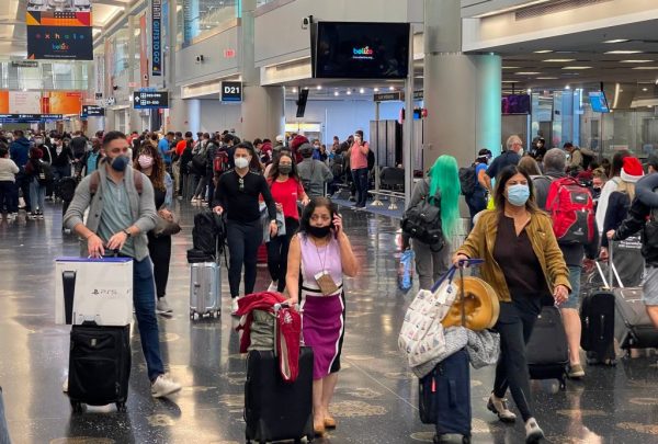 Los viajeros usan mascarillas en el Aeropuerto Internacional de Miami el 24 de diciembre de 2020, en medio de la pandemia de covid-19. (Foto de DANIEL SLIM / AFP a través de Getty Images)