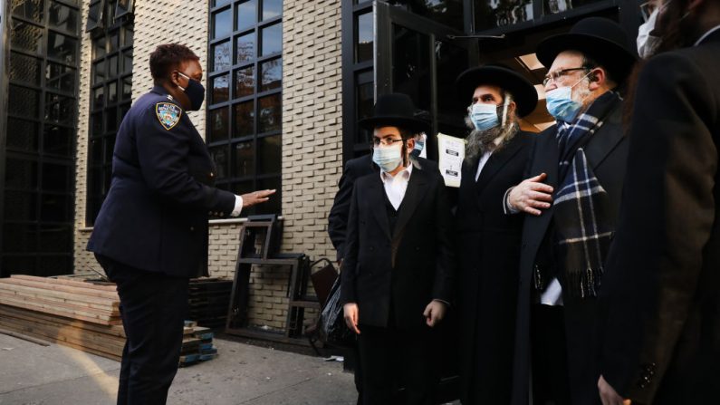Miembros de la policía de Nueva York se paran afuera mientras las personas se congregan afuera de la sinagoga Congregation Yetev Lev D'Satmar el 19 de octubre de 2020 en el vecindario de Williamsburg en el distrito de Brooklyn de la ciudad de Nueva York (EE.UU.). (Foto de Spencer Platt / Getty Images)