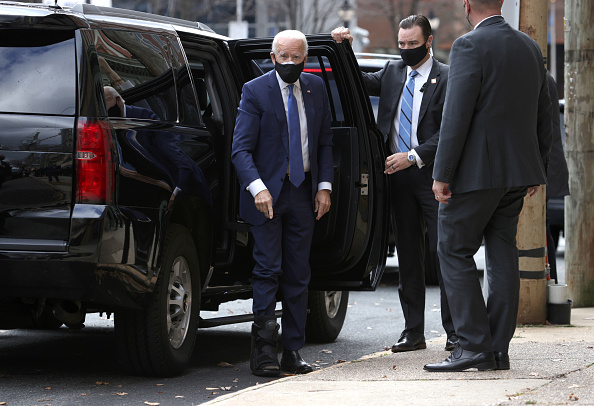 El candidato presidencial demócrata Joe Biden señala la bota ortopédica que usa al llegar al Queen Theatre en Wilmington, Delaware, el 1 de diciembre de 2020. (Photo by Alex Wong/Getty Images)