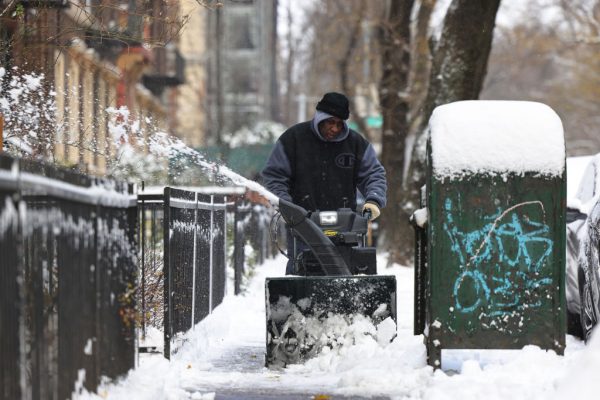 Un hombre limpia la nieve de la acera en el barrio Flatbush de Brooklyn el 17 de diciembre de 2020 en la ciudad de Nueva York (EE.UU.). (Foto de Michael M. Santiago / Getty Images)
