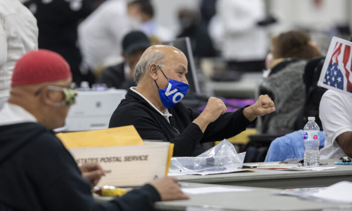 Un trabajador, del Departamento de Elecciones de Detroit, celebra después de escuchar que el número, casi final, de 167,000 boletas ausentes contabilizadas se anuncia por altavoz en la Junta Central de Conteo, en el Centro TCF, el 4 de noviembre de 2020. (Elaine Cromie/Getty Images)