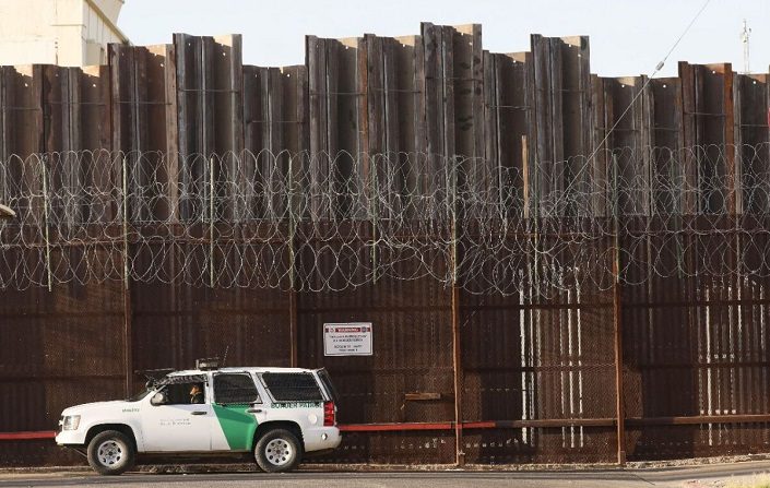 Un agente de la Patrulla Fronteriza se encuentra estacionado frente al muro fronterizo entre EE. UU. y México en el Condado de Imperial, que se ha visto duramente golpeado por la pandemia de COVID-19 en Calexico, California, el 24 de julio de 2020. (Mario Tama/Getty Images)