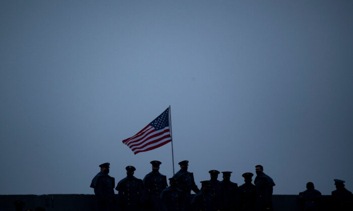 Miembros del ejército se paran cerca de la bandera de EE.UU. durante un partido de fútbol entre el Ejército y la Marina, en el estadio Michie de West Point, en Nueva York, el 12 de diciembre de 2020. (Brendan Smialowski/AFP a través de Getty Images)