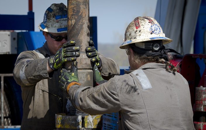 Los trabajadores cambian las tuberías en la plataforma de perforación de gas horizontal de Consol Energy que explora Marcellus Shale en las afueras de la ciudad de Waynesburg, Pensilvania, el 13 de abril de 2012. (MLADEN ANTONOV/AFP a través de Getty Images)